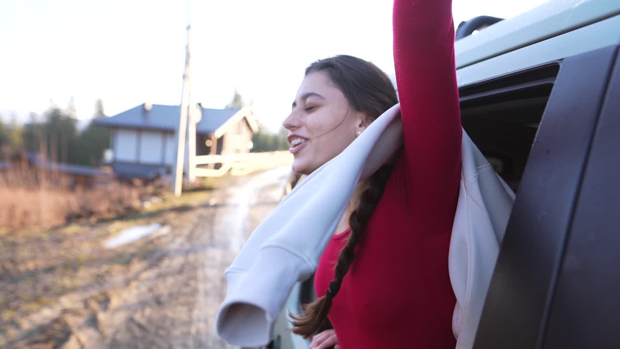 mujer feliz mirando por la ventana del coche
