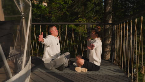 couple practices yoga extending arms. husband and wife inhales fresh air embracing meditative state in sustainable surroundings. mindful practices