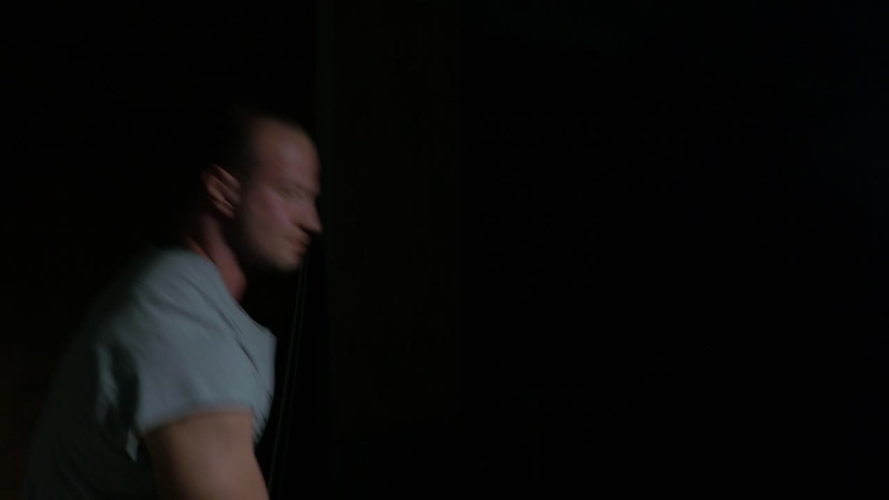 Man Working Out in a Dark Room
