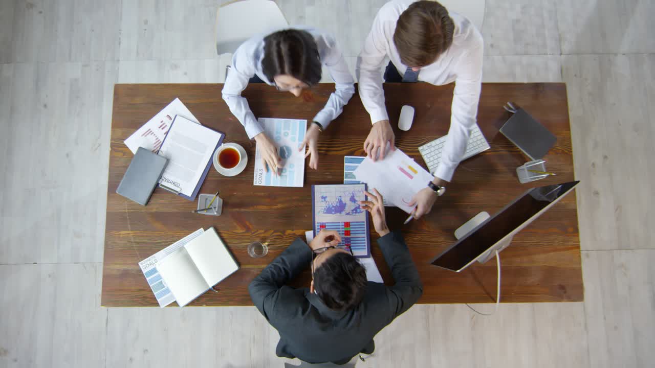 Top View Shot Of Business Consultant And Businesspeople Sitting At Table And Discussing Documents