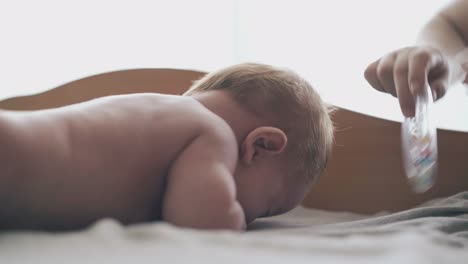 restless infant lies on stomach and nurse makes massage