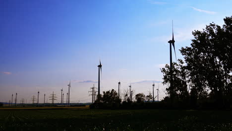 wind turbines generate energy at sunset. wind turbines stand tall against a colorful sunset, harnessing renewable energy amidst an open green landscape