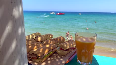 deliciosos sándwiches en un hermoso bar de playa con jugo de naranja fresco, disfrutando del verano con unas vacaciones de ensueño con vistas al mar en ibiza españa, destino de vacaciones, tiro de 4k