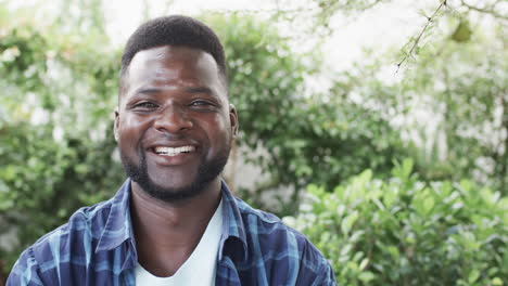 African-American-man-smiles-brightly-outdoor,-with-copy-space