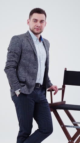 businessman posing beside a director's chair
