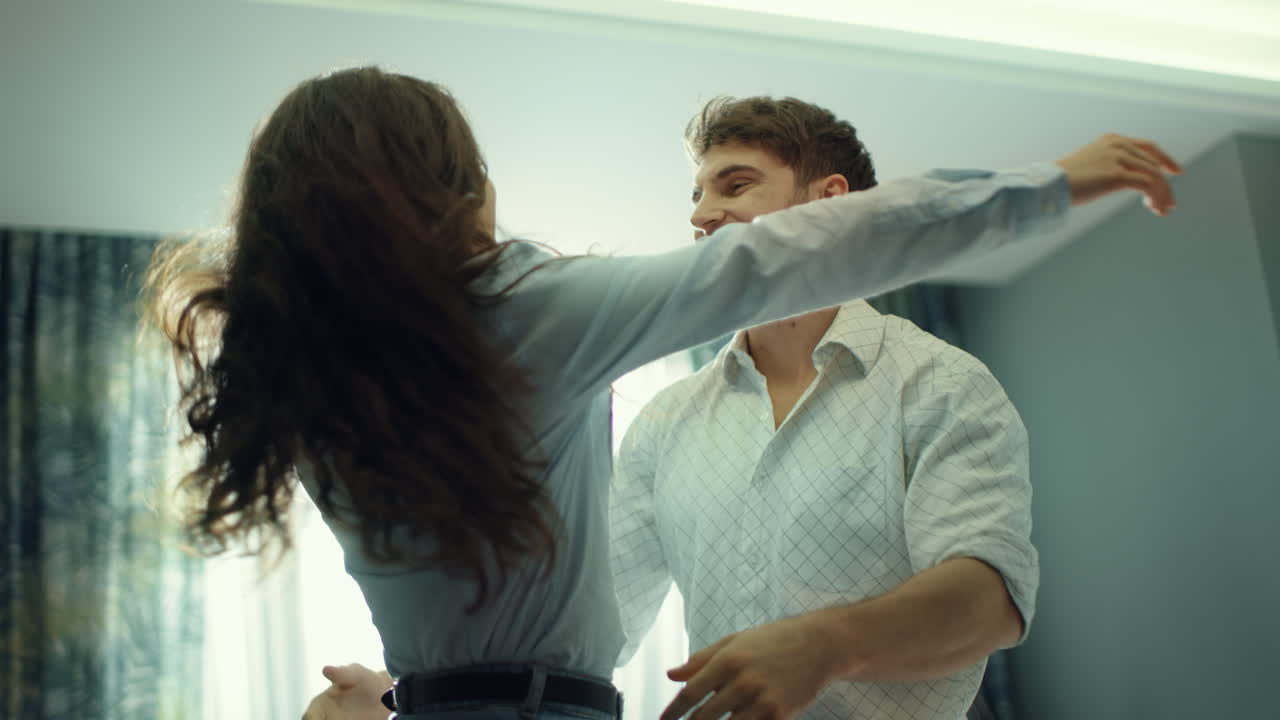 Casal animado se divertindo no hotel. Homem fazendo uma surpresa para a mulher no quarto.