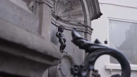 manneken pis vu de derrière la clôture dans le centre-ville de bruxelles, belgique