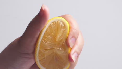 hand squeezes fresh natural juice out of the lemon