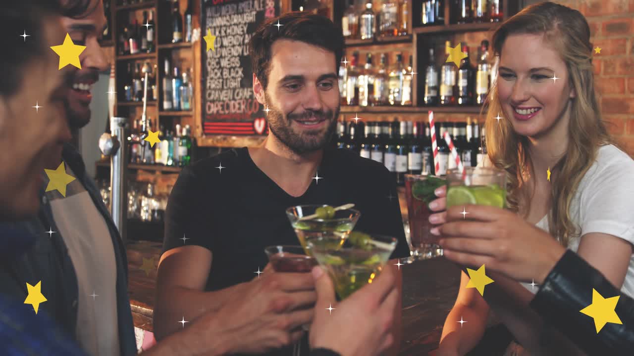 Bearded man lifting martini at bar leading crew raising drinks cheering stars popping over glasses