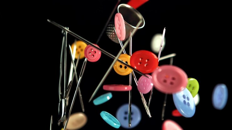 Colorful Sewing Buttons and Needles Falling and Rising on Black Background