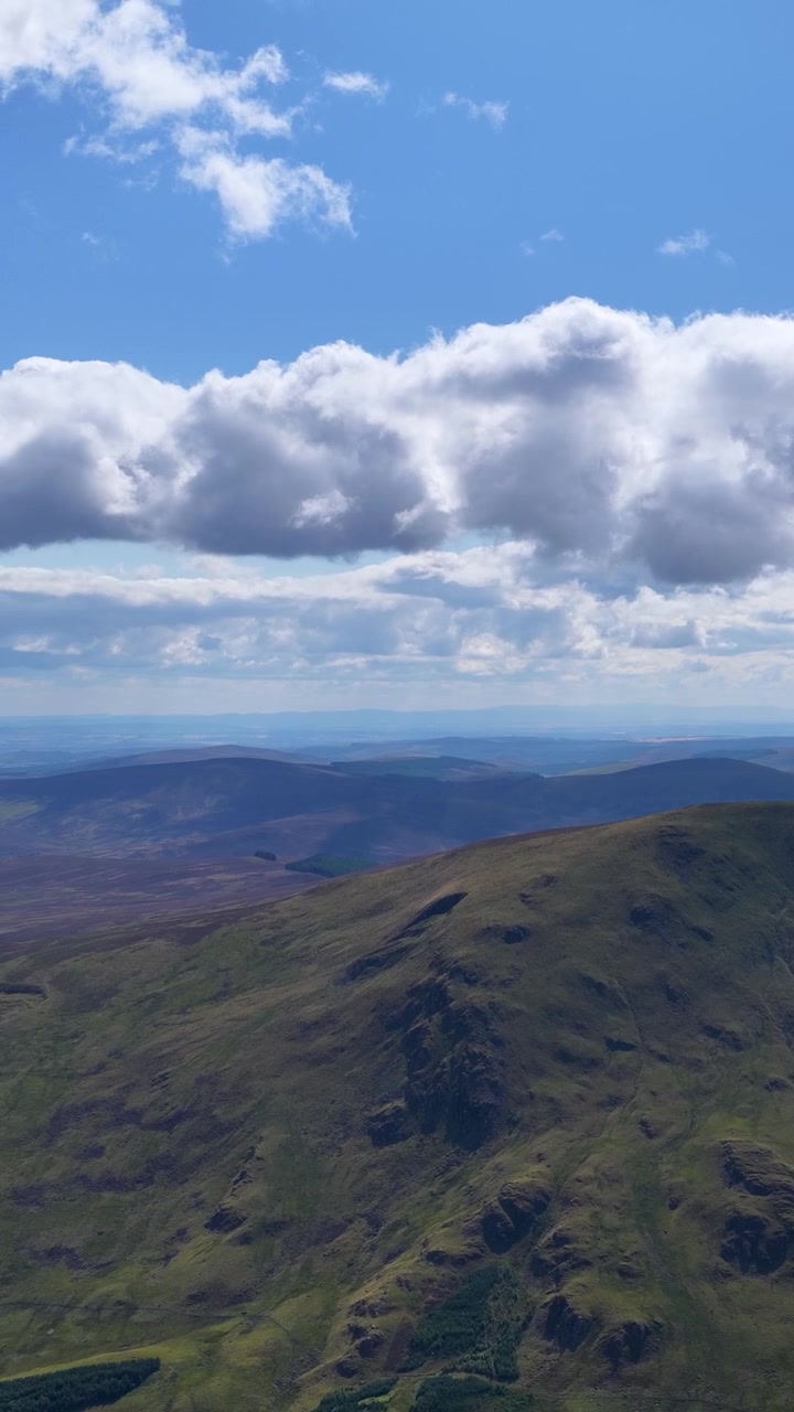 Un drone sorvola le Highlands scozzesi ricoperte di erica, rivelando valli, montagne e drammatiche ombre di nuvole.