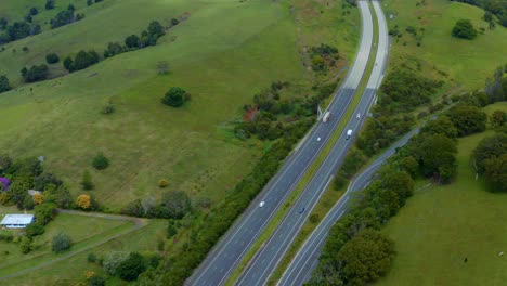 m1 pacific motorway - vehicles driving on carriageway passing by lush green fields in byron bay, queensland, australia