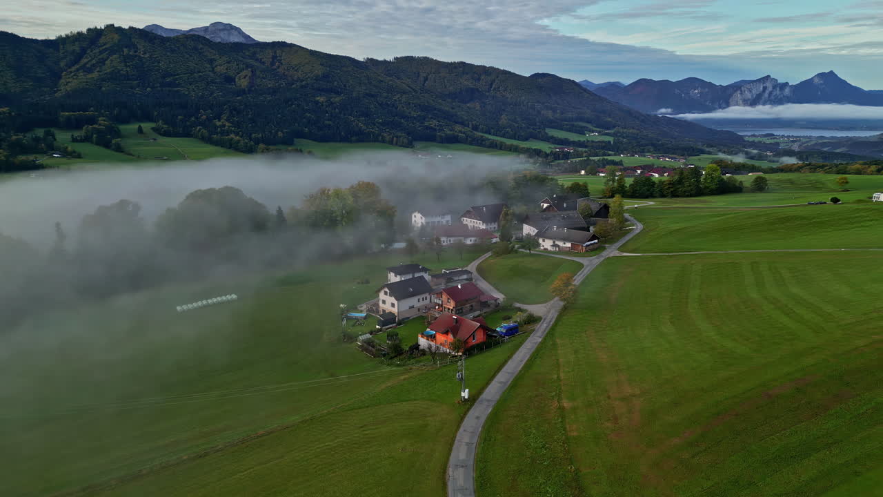 niebla matinal moviéndose entre las colinas en un pequeño pueblo en austria