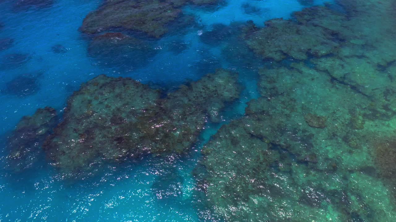 드론이 제공하는 조감도는 블루 라군의 매혹적인 투명도를 보여 바위와 해양 생물의 숨겨진 아름다움을 드러냅니다.