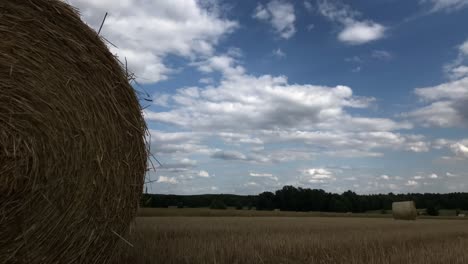 Der-Zeitraffer-Zeigt-Die-Schönheit-Der-Strohballen-Auf-Dem-Land,-Begleitet-Vom-Sanften-Plätschern-Der-Regentropfen,-Die-Von-Den-Blättern-Fallen