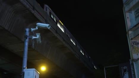 Surveillance Cameras at Night with Urban City Train passing by, Urban Concrete Jungle Night Scene, Bangkok BTS Skytrain at Night