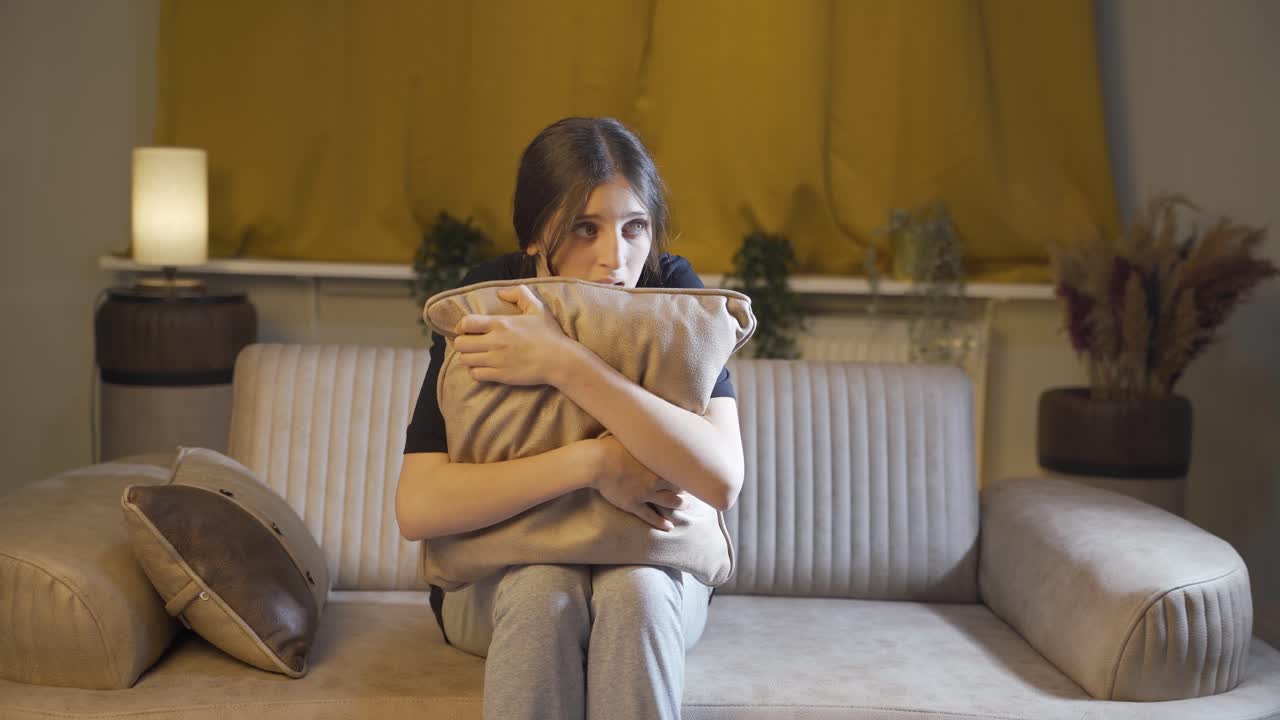 두려움으로 주위를 둘러보는 젊은 여성.