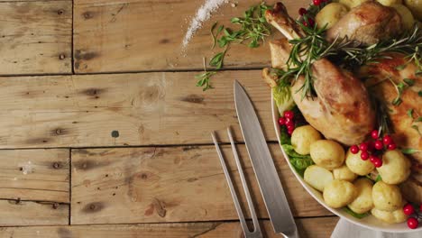 video of tray with roasted turkey, potatoes and cutlery on wooden surface