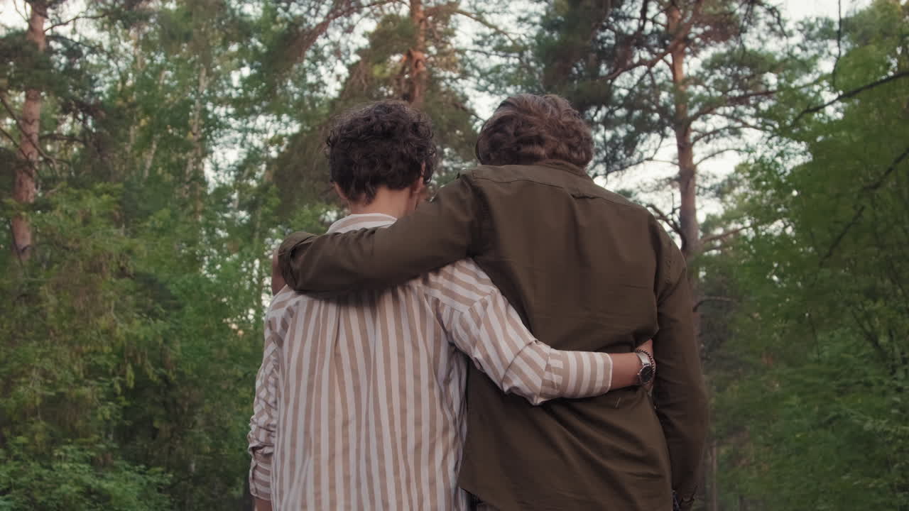 Hugging Couple Strolling Down Path In Forest