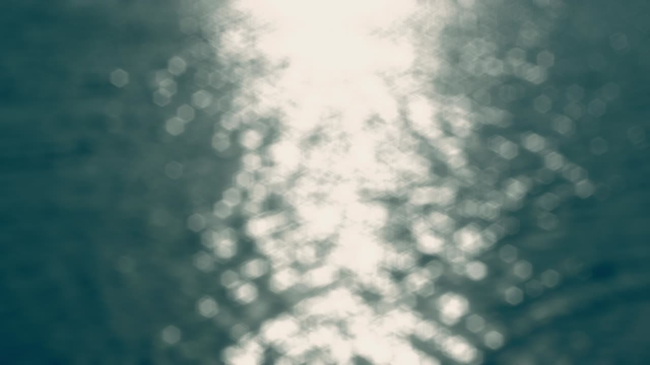 By the Water - Seamless loop of a completely defocused 4k-shot of a beautiful rippling and sparkling water surface in muted colors