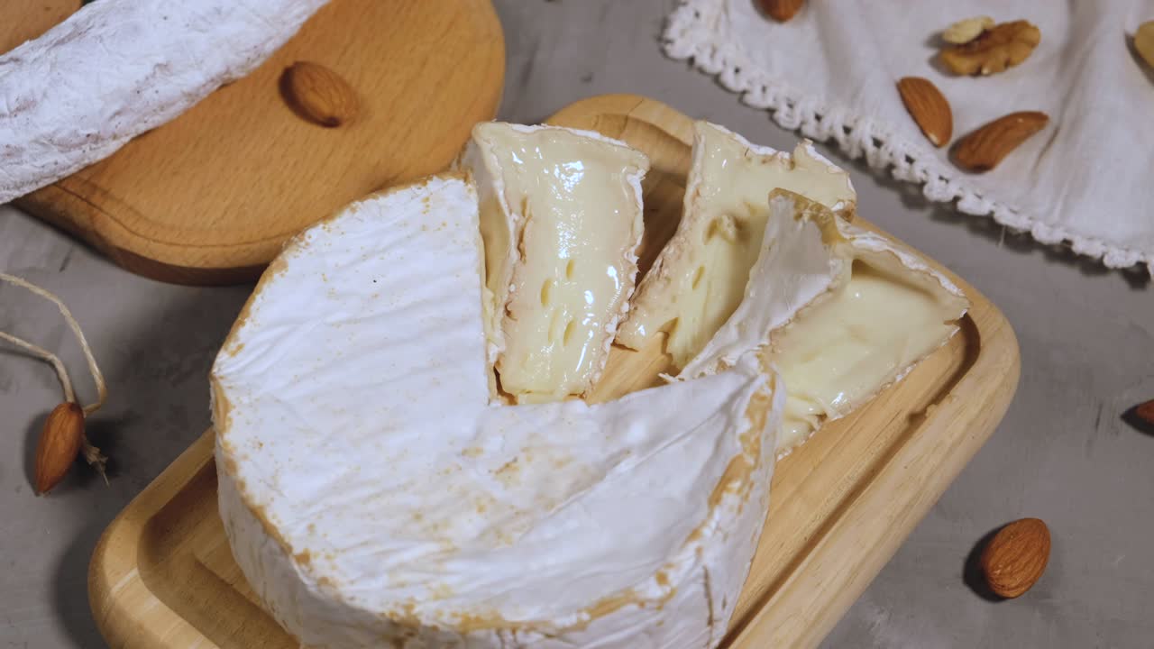 trozo redondo de queso brie y salchicha en una tabla de madera