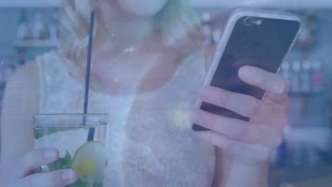 animation of globe over caucasian businesswoman using smartphone