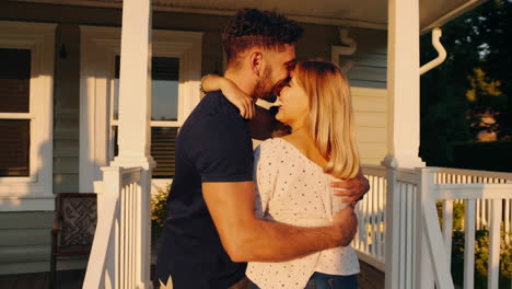 a multi-racial family embracing on their home porch