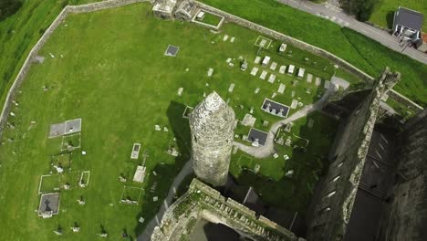 aerial drone shot of castle and grassy landscapes in ireland