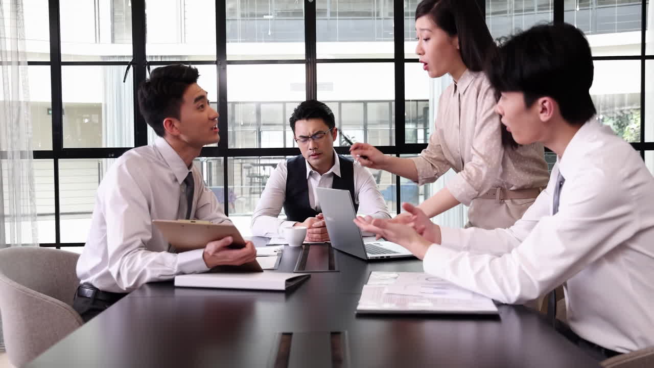 商务办公同事在公司会议上围绕文件激烈争论，互相指责，在讨论不佳工作表现时气氛日益紧张。