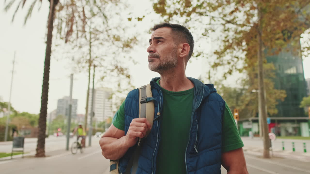 Uomo con zaino che cammina per la strada