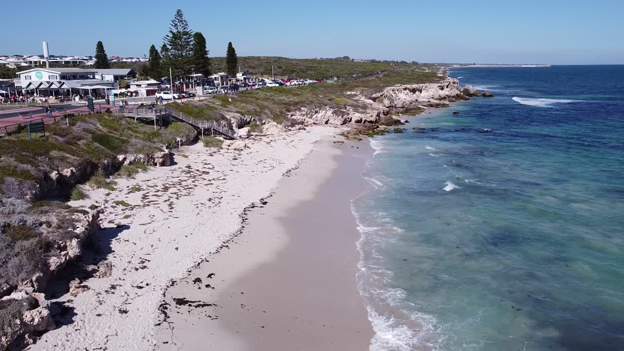 지역 카페,  ⁇  모래 해변 과 인도양 의  ⁇ 은 파란 물 은 방문자 들 을 끌어들이고 있다