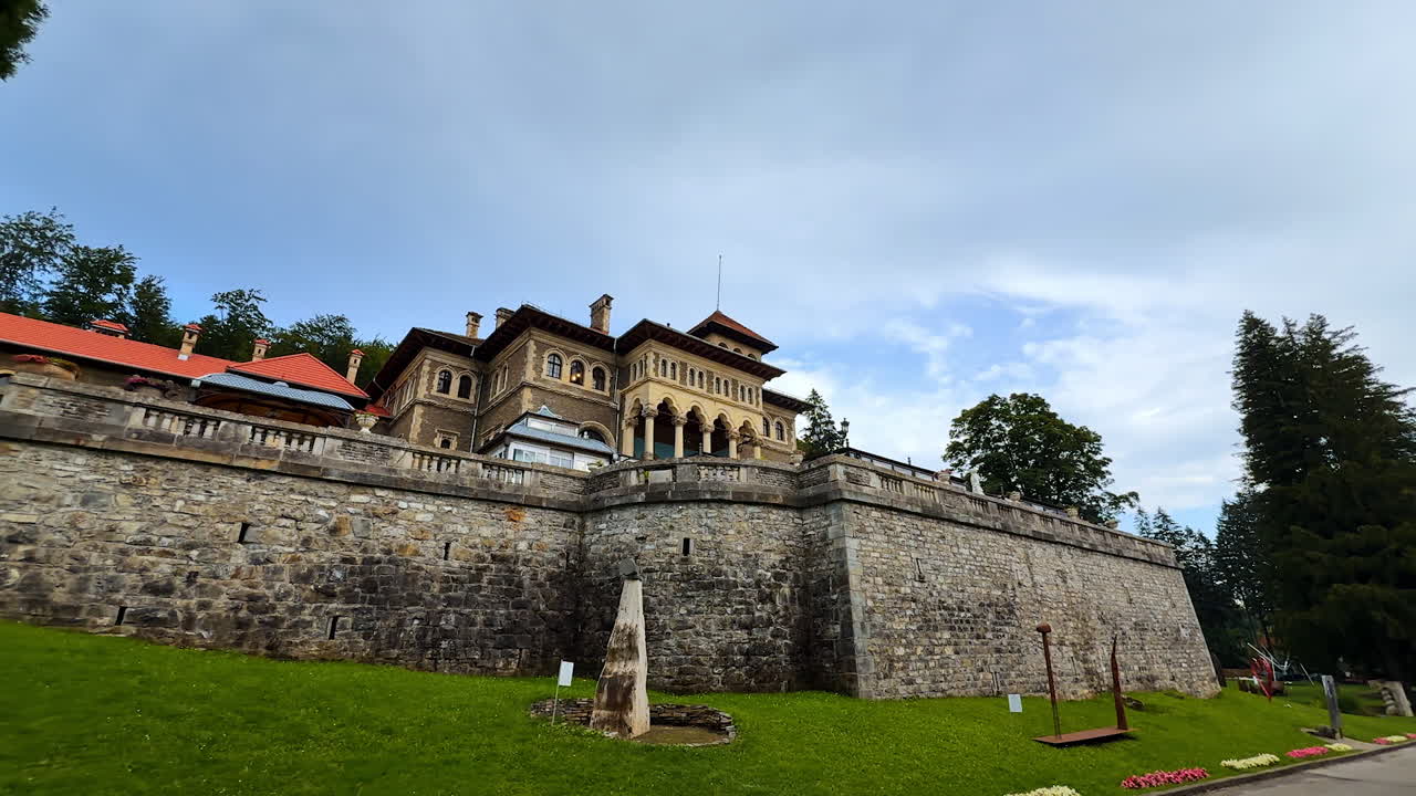 Busteni, Romania, 17 July 2025: Walking by the road along the terrace of the castle. Watching the territory of Cantacuzino Castle in Busteni, Romania on gloomy day