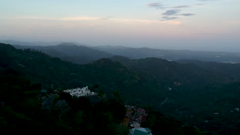 Footage-of-drone-flying-above-mountains-with-houses-between-them-and-the-city-of-Cebu-Philippines-in-the-background