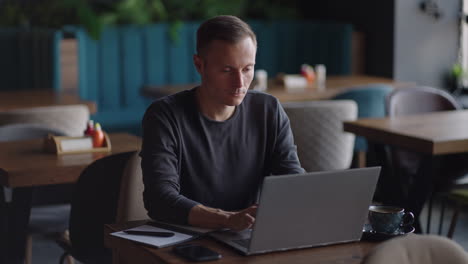 beautiful male developer or student working studying by laptop in cafe. freelance remote work online education self employed