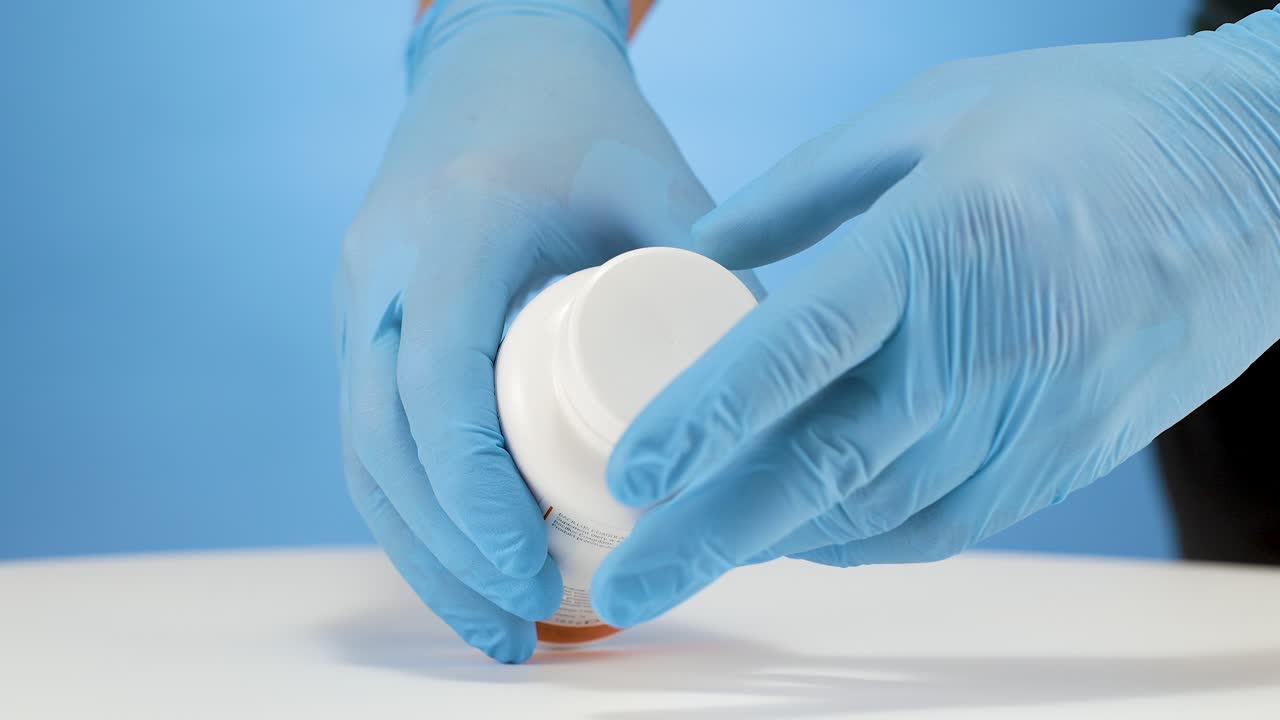 el médico abre la tapa blanca para revelar las cápsulas amarillas de omega 6