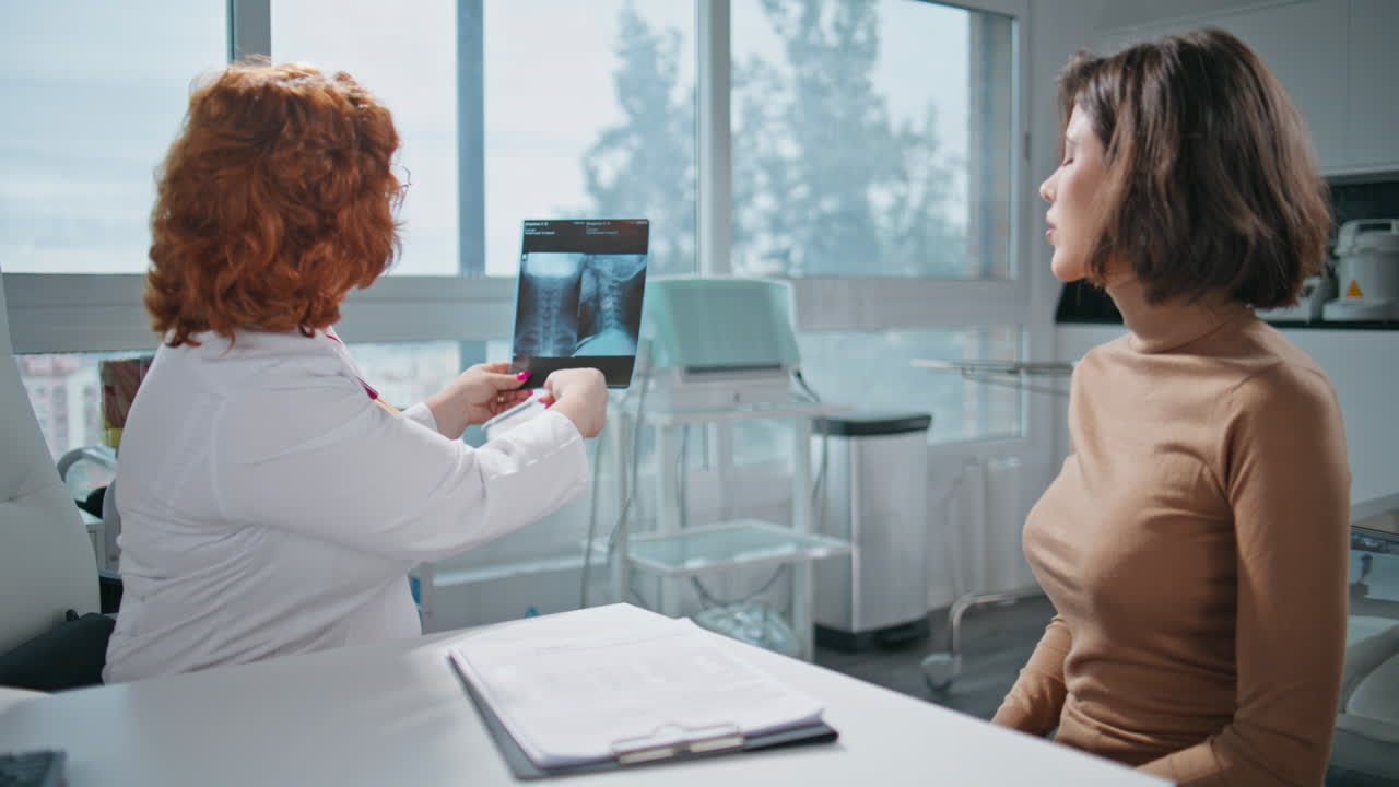 Doctor reviewing x-ray results with patient in clinic office closeup. Physician