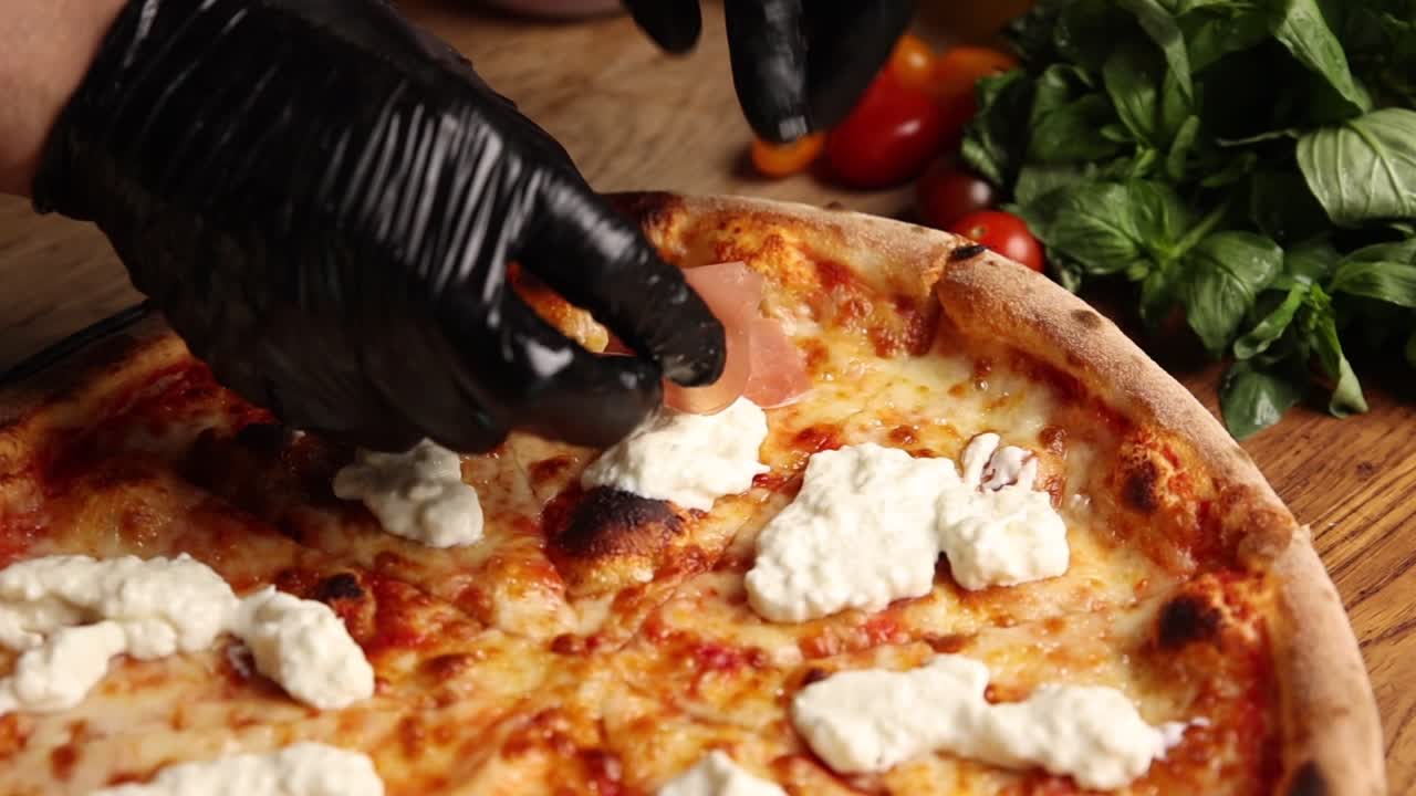 Chef's Hands Placing Prosciutto on Freshly Baked Pizza