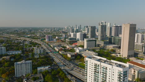 Vista-Panorámica-Aérea-Del-Municipio-Urbano.-Incline-Hacia-Abajo-En-La-Concurrida-Autopista-De-Varios-Carriles-Y-El-Brillante-Sol-Bajo-Que-Proyecta-Largas-Sombras.-Miami,-Estados-Unidos