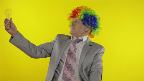 el viejo payaso empresario empresario muestra bombilla. se le ocurrió una gran idea
