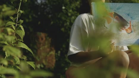 Young-Indian-girl-showing-expressionist-painting-with-bushes-on-the-foreground