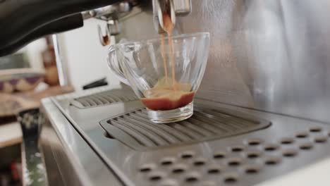 close up of coffee pouring into cup from coffee machine at coffee shop, slow motion