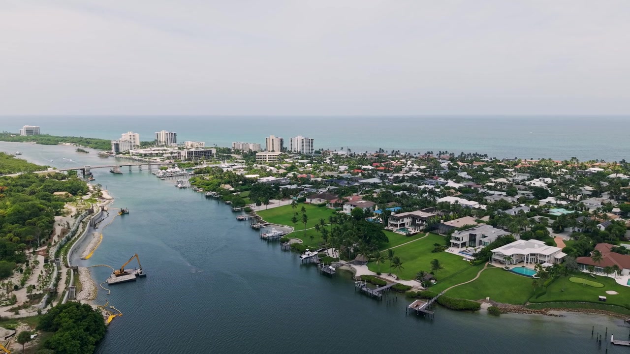 Ripresa aerea in allontanamento lungo il fiume Indiano di Jupiter Inlet con case sul lungomare e costa atlantica, drone, West Palm Beach Florida USA