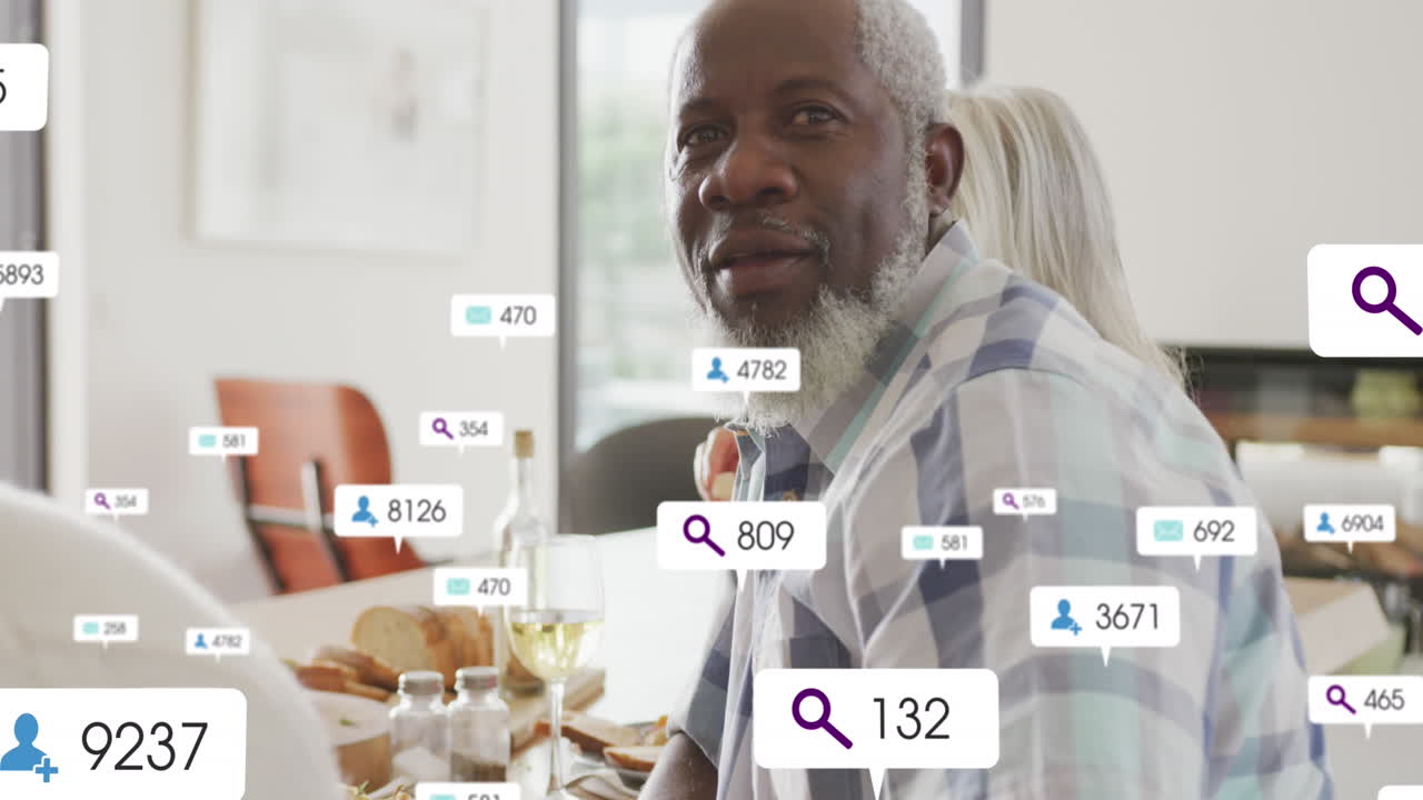 Animation of social media icons and numbers over senior diverse couple at home