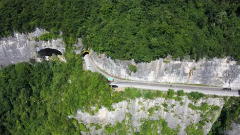 在中國河北省,在陽光明<unk>的日子中,空中拍攝的道路上,交通經過令人震驚的森林,高海拔和<unk>曲的道路.