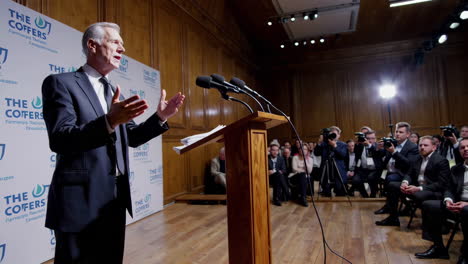 a man speaks at a podium during a press conference or public event