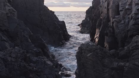 olas de marea rodando en un cañón rocoso al atardecer en cámara lenta