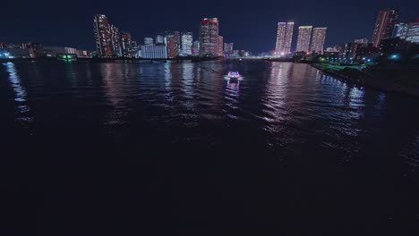 Night-light-Tokyo,-Tsukuda,-Toyosu-skyscrapers-and-bridge-the-Sumida-River-Yakatabune,-pleasure-boat