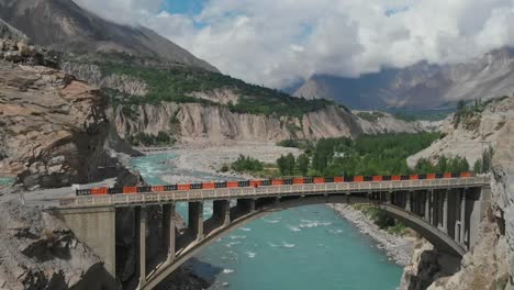 aerial view of arch bridge crossing the hunza river in ganish valley, pakistan. dolly back