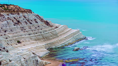 time lapse shot of crashing waves of atlantic against rocky cliffs and shore of sicily in italy