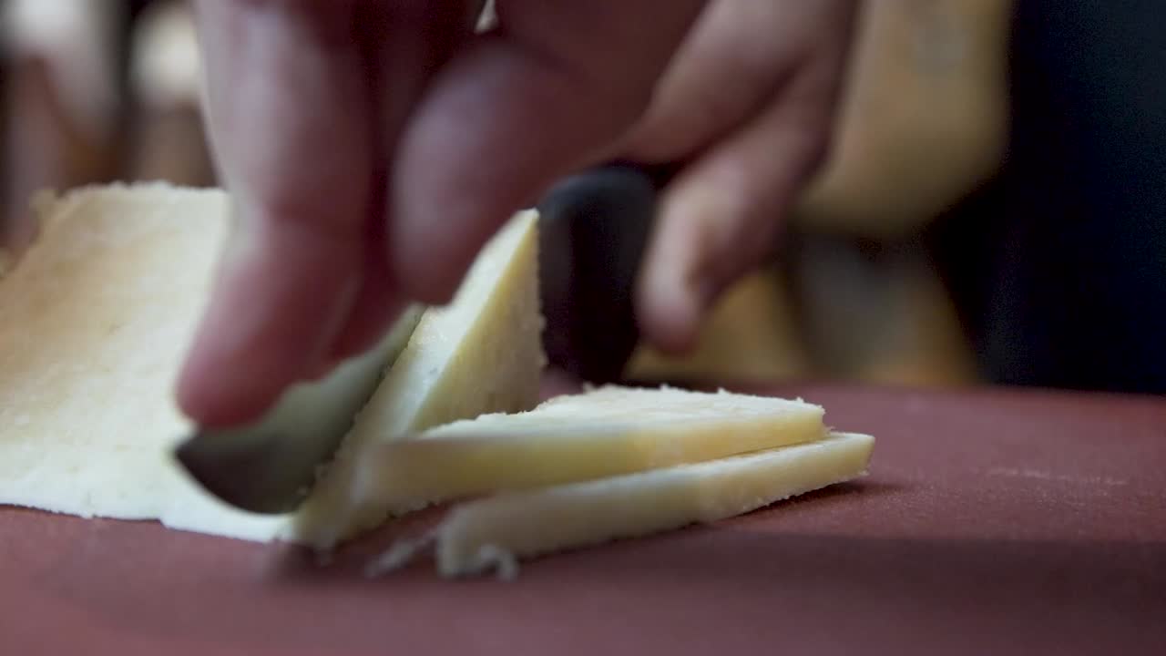 Cutting a block of hard cheese